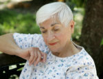 A sweet senior lady in the park resting and remembering.