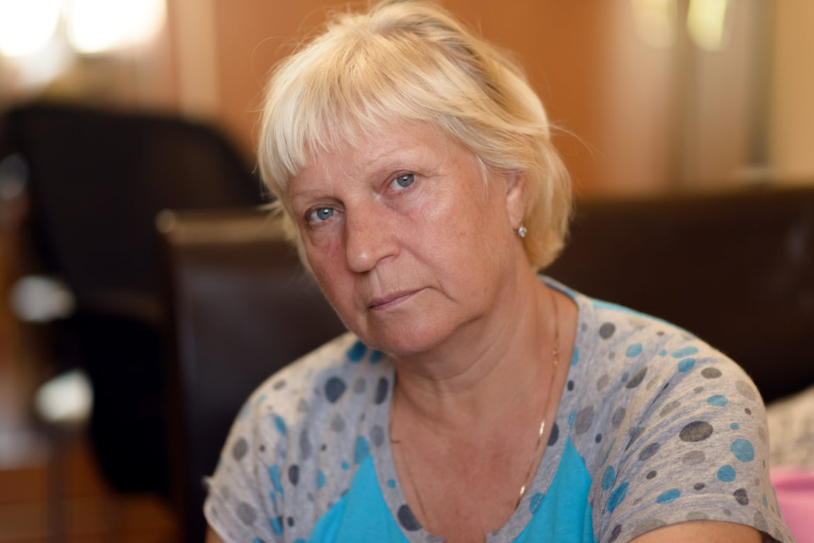 Portrait of a aged woman at the kitchen. Selective focus with shallow depth of field.