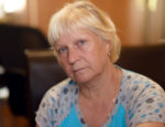 Portrait of a aged woman at the kitchen. Selective focus with shallow depth of field.
