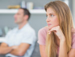 Couple not talking after a dispute on the couch in living room at home